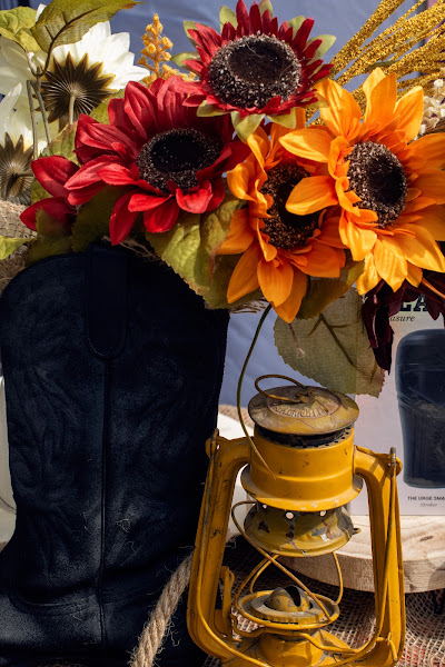 Un bouquet de fleurs rouges et jaunes accompagne une lanterne dans un décor western