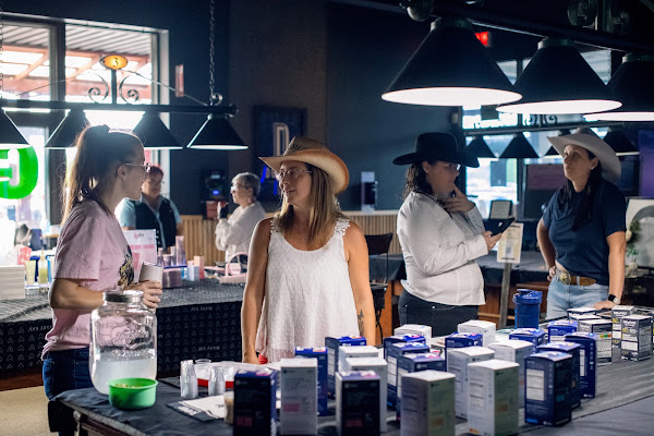 Des participantes en chapeaux western échangent autour des kiosques du salon